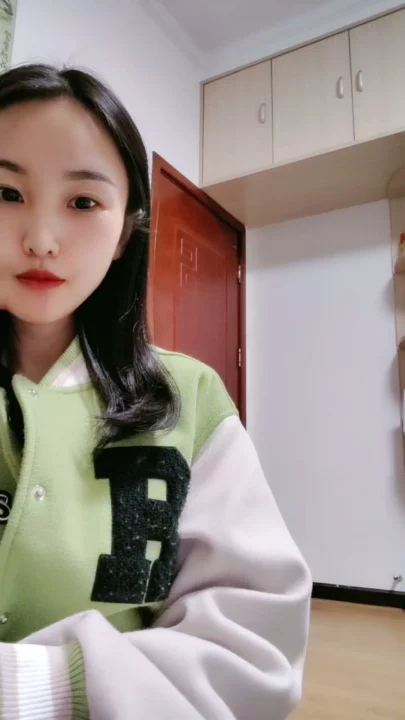 Screenshot 13 aus Petite Asiatin solo am Teasen — Varsity-Jacke und verführerische Posen im Studentenzimmer