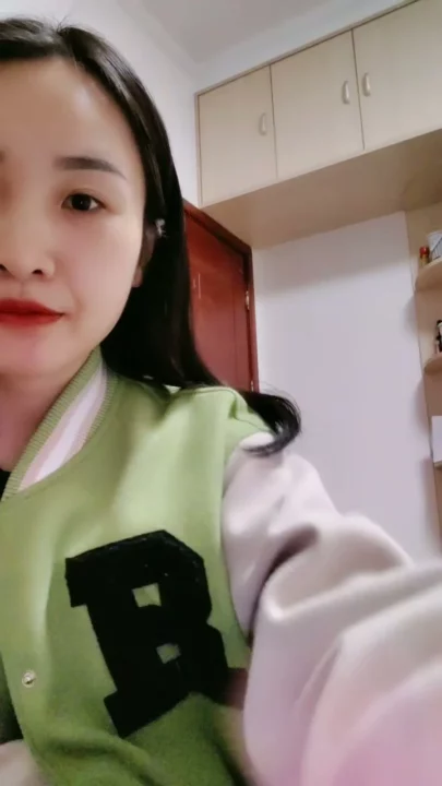 Screenshot 3 aus Petite Asiatin solo am Teasen — Varsity-Jacke und verführerische Posen im Studentenzimmer