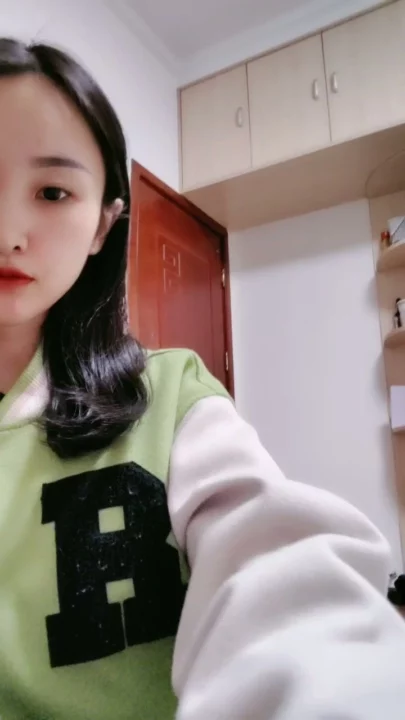 Screenshot 6 aus Petite Asiatin solo am Teasen — Varsity-Jacke und verführerische Posen im Studentenzimmer