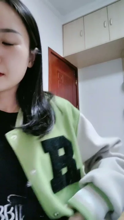 Screenshot 9 aus Petite Asiatin solo am Teasen — Varsity-Jacke und verführerische Posen im Studentenzimmer