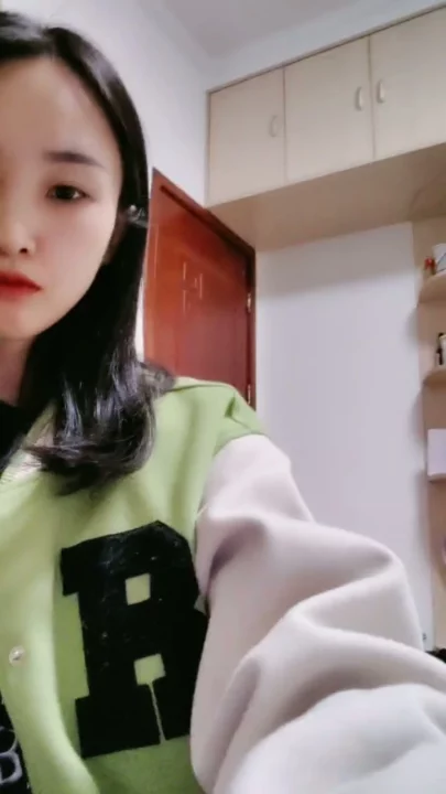 Screenshot 10 aus Petite Asiatin solo am Teasen — Varsity-Jacke und verführerische Posen im Studentenzimmer